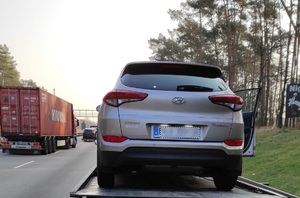 Hyundai Tuscon odjeżdża na lawecie na parking strzeżony auto koloru szarego stoi na lawecie pojazdu