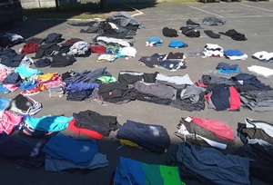 Podrobione ubrania zatrzymane w Krotoszynie na ziemi leżą porozkładane podrobione ubrania