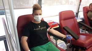 Na straży życia - akcja honorowego oddawania krwi na fotelu siedzi kobieta w czarnej bluzce i oddaje krew