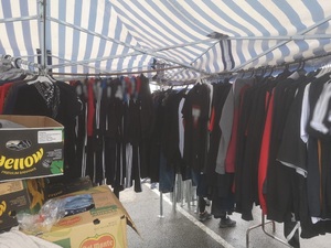 Stoisko, na którym handlowano podrabianymi ubraniami Stoisko a na nim rozwieszone podrabiane ubrania różnych znanych marek
