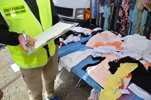 Podrobione ubrania na stoisku w Bielawie Podrobione ubrania na stoisku w Bielawie, obok stoi funkcjonariusz Straży Granicznej