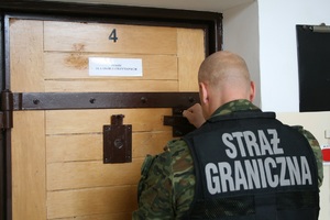 Funkcjonariusz Straży Granicznej zamyka pomieszczenie dla osób zatrzymanych Funkcjonariusz Straży Granicznej zamyka pomieszczenie dla osób zatrzymanych