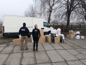 Zatrzymane wyroby tytoniowe bez polskich znaków skarbowych akcyzy spakowane w pudła i worki. W tle zatrzymany samochód służący do przewożenia konrabandy Zatrzymane wyroby tytoniowe bez polskich znaków skarbowych akcyzy spakowane w pudła i worki. W tle zatrzymany samochód służący do przewożenia konrabandy